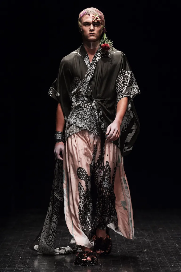 A dark kimono jacket with black-and-white patterned panels over wide powder-pink trousers with black cactus forms.