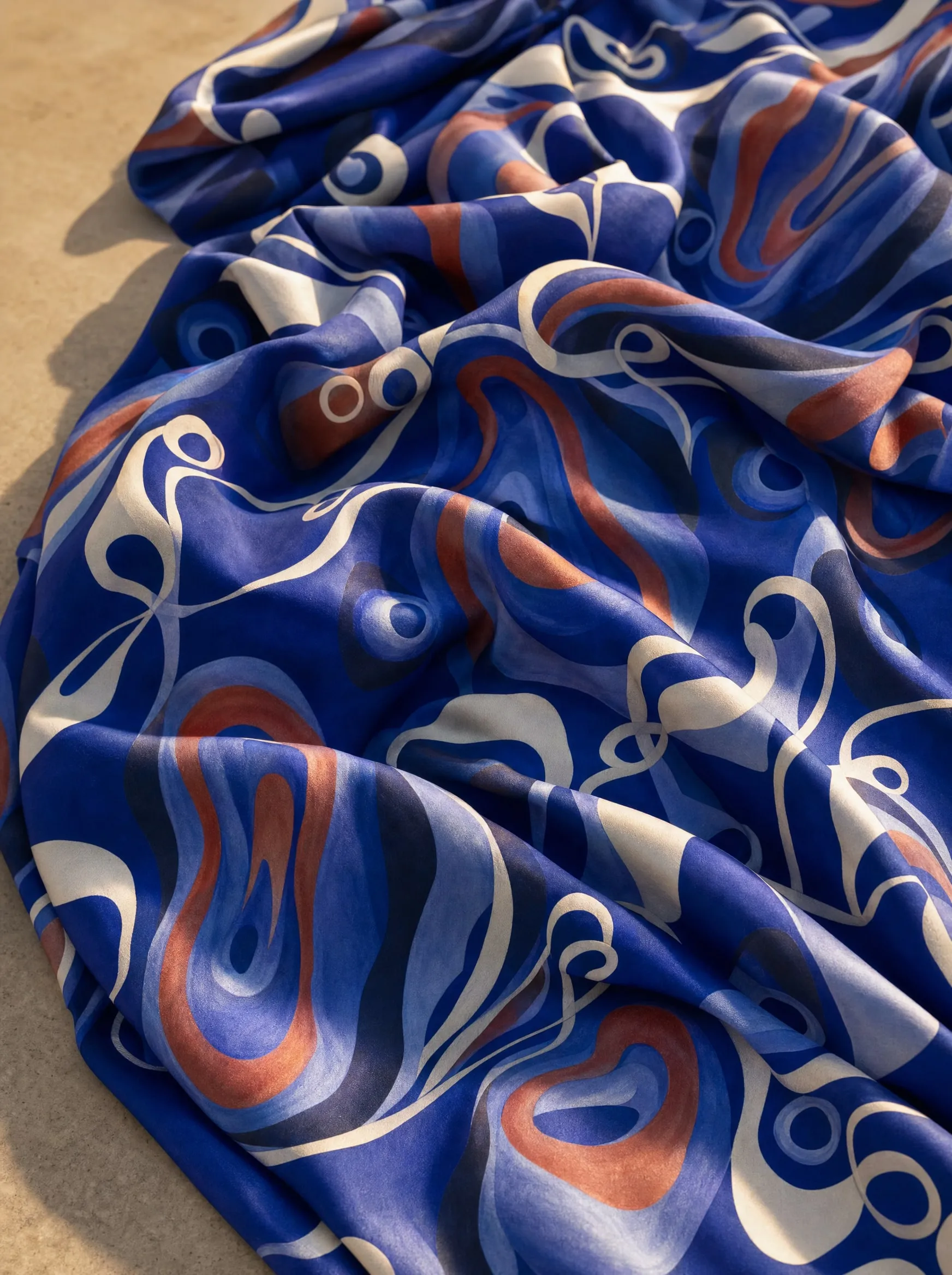 A visualisation presents Homage to O’Keeffe on draped fabric, with layered organic forms in blue, rust and white against dark blue.