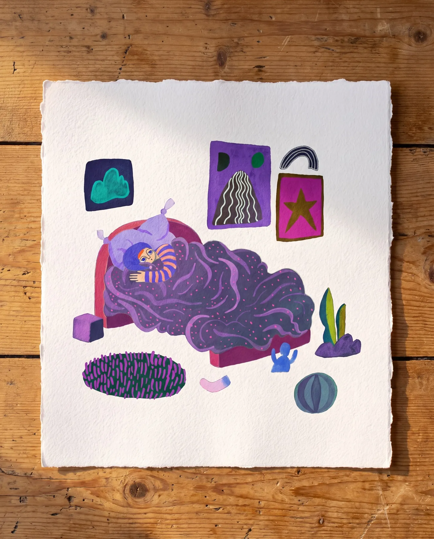Ett andra original ur boken, gouache på akvarellpapper med riven kant på ett trägolv: barnet i randig pyjamas ligger vaket i en säng under ett böljande mörklila täcke med rosa prickar, omgivet av tavlor med moln, randigt berg, guldstjärna och en regnbåge, en grönlila matta, en växt och en boll — verk av Amandah L'Narte