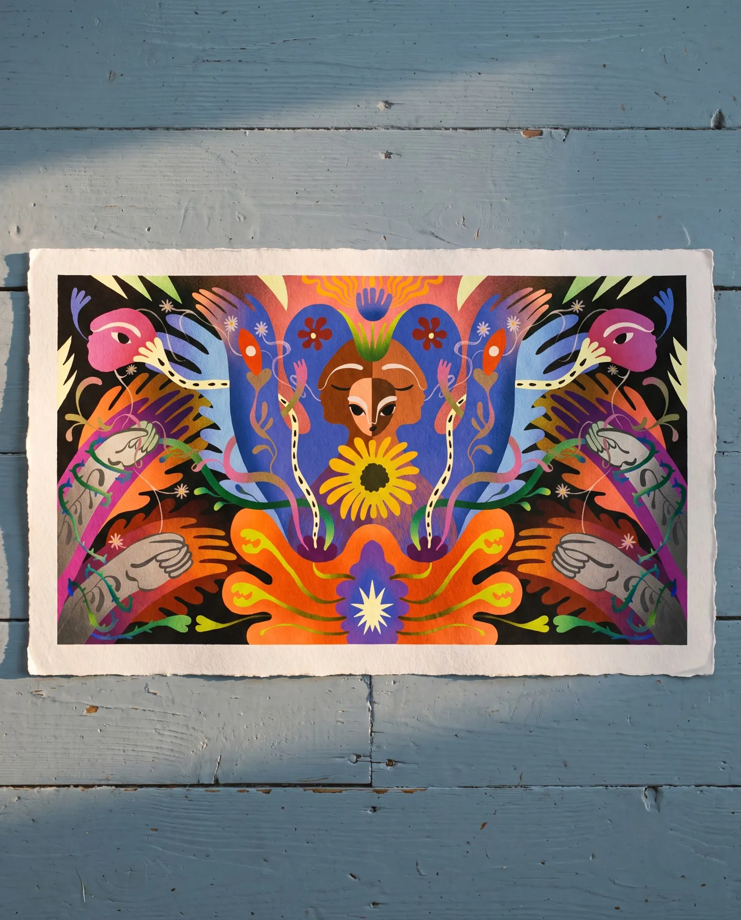 Amnesty’s 2026 calendar illustration is presented in a mock-up on deckle-edged paper in sunlight against pale-blue wooden boards, showing the symmetrical motif of the woman, sunflower and thorny vines.