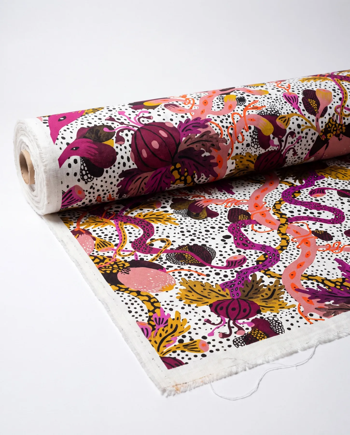 A visualisation presents the fabric on a roll, with plum-coloured flowers, ochre foliage and pink tendrils across a dotted white ground.