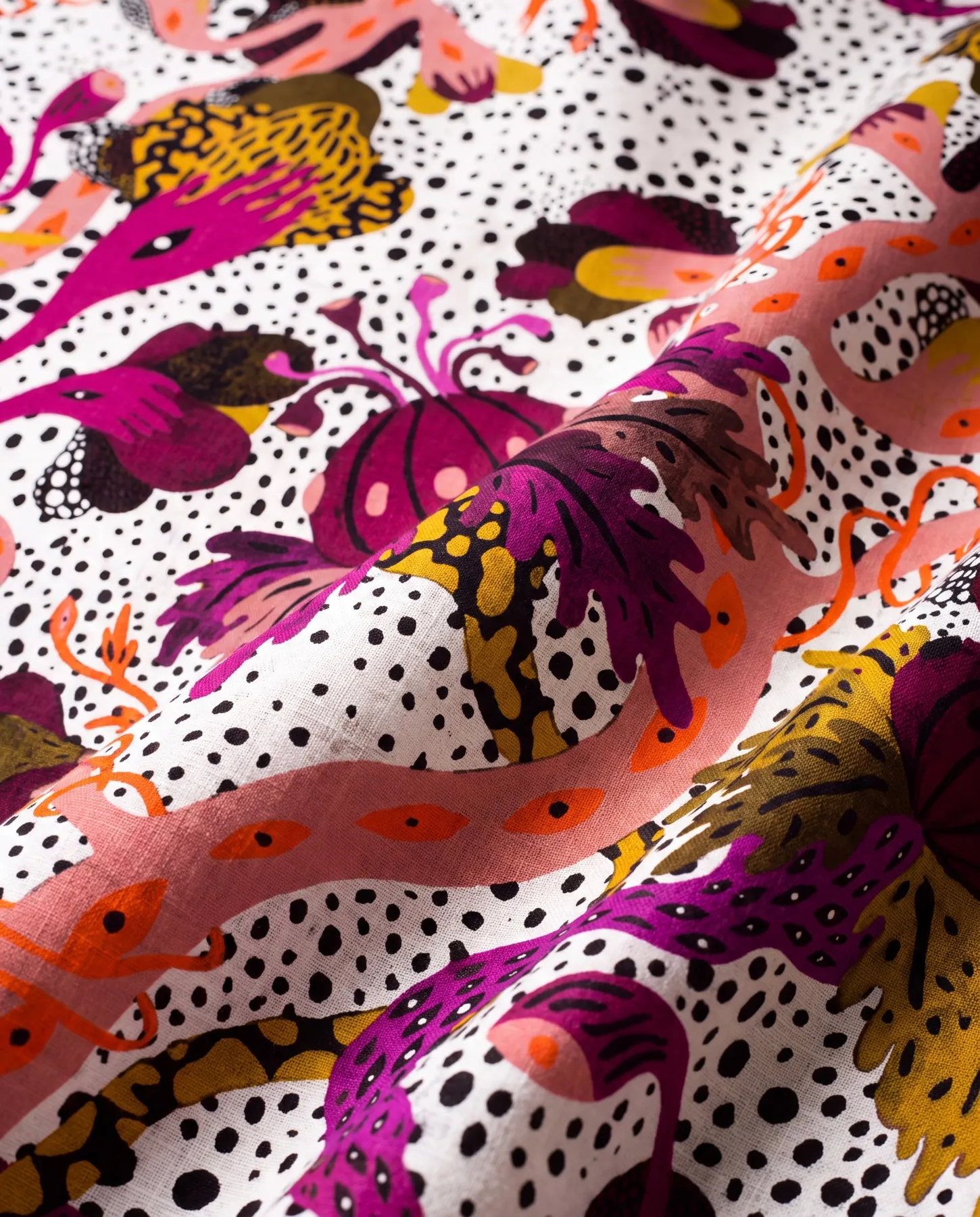 A visualisation presents the fabric draped in a diagonal fold, with pink and orange tendrils crossing magenta flowers, ochre foliage and a black-dotted ground.